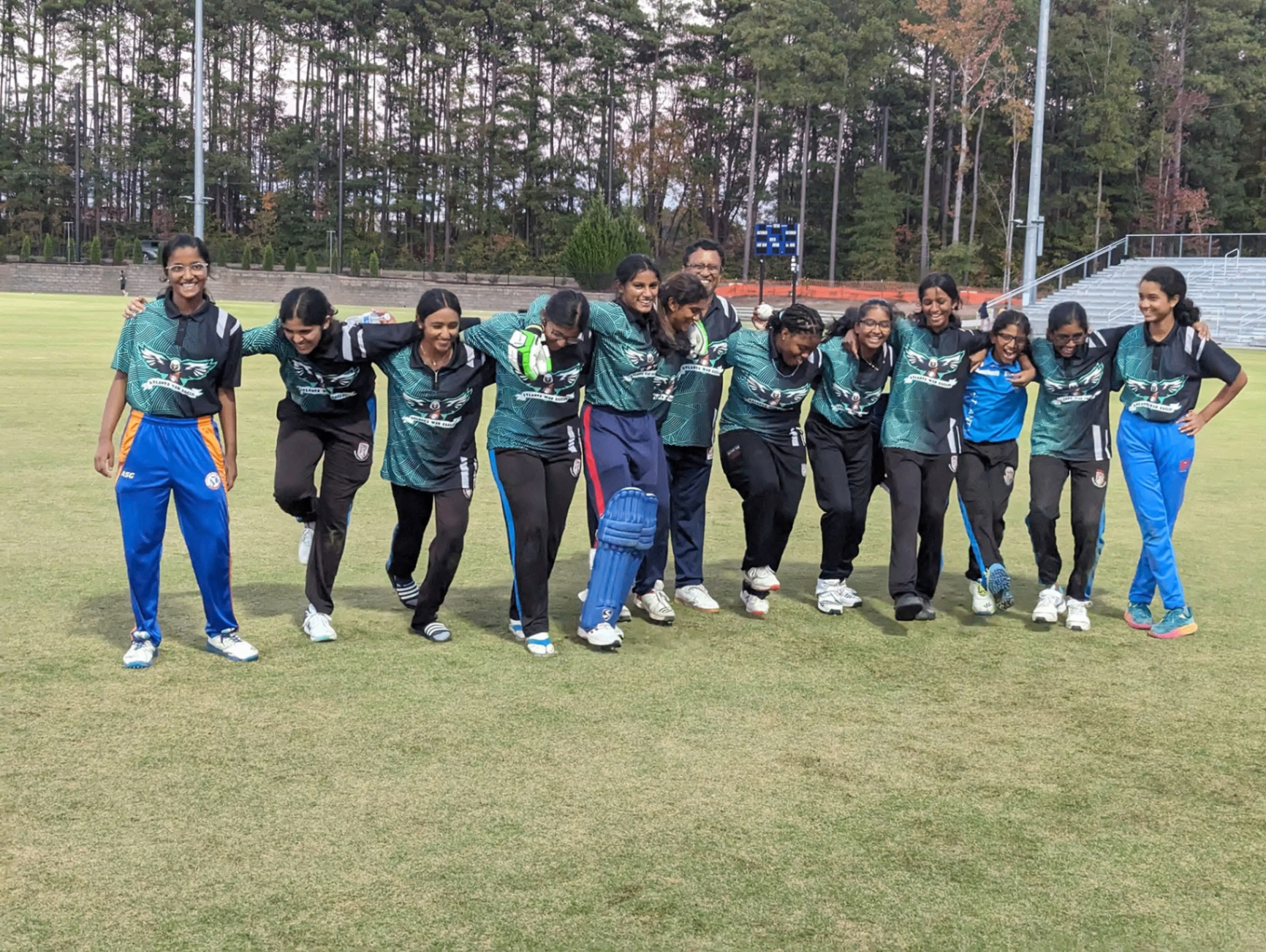 SN Cricket Academy players celebrating together on the field with arms around each other after a match